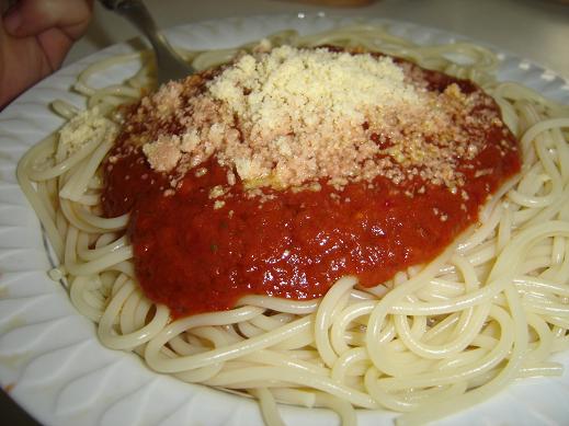 Spaghetti cooked and served with tomato sauce